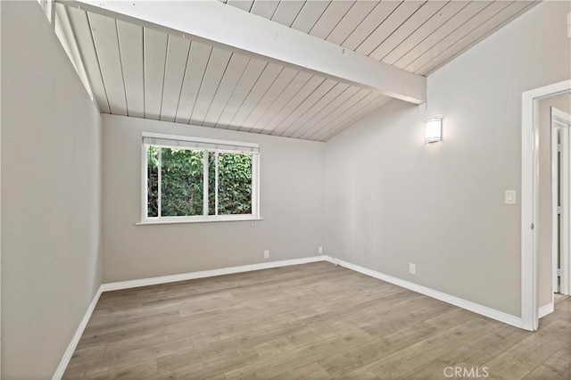 spare room featuring baseboards, lofted ceiling with beams, wood ceiling, and wood finished floors