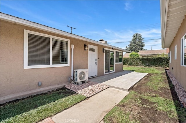 property entrance featuring a patio area, ac unit, and stucco siding