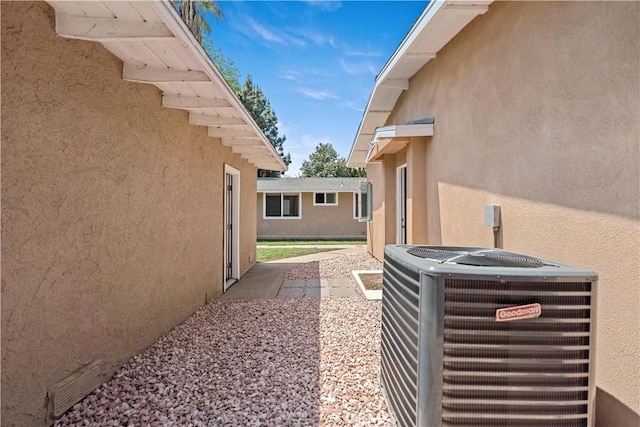 exterior space with central AC unit and stucco siding