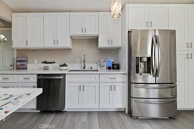 kitchen featuring dishwashing machine, stainless steel refrigerator with ice dispenser, a sink, and white cabinetry