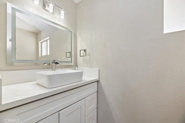 bathroom with vanity and a textured wall