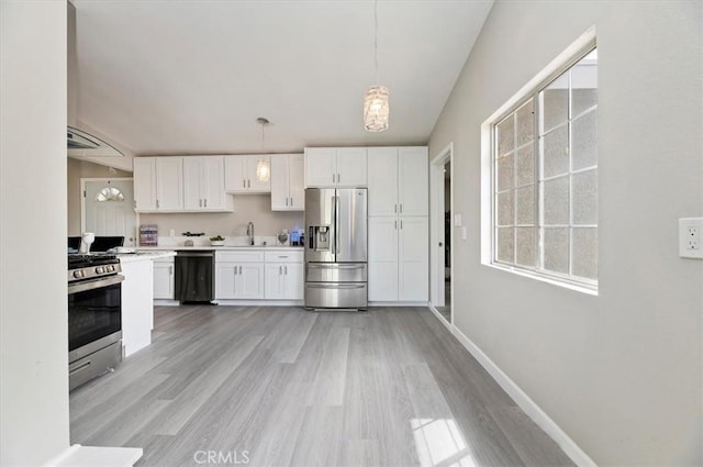 kitchen featuring light countertops, white cabinets, light wood-style flooring, a wealth of natural light, and stainless steel appliances