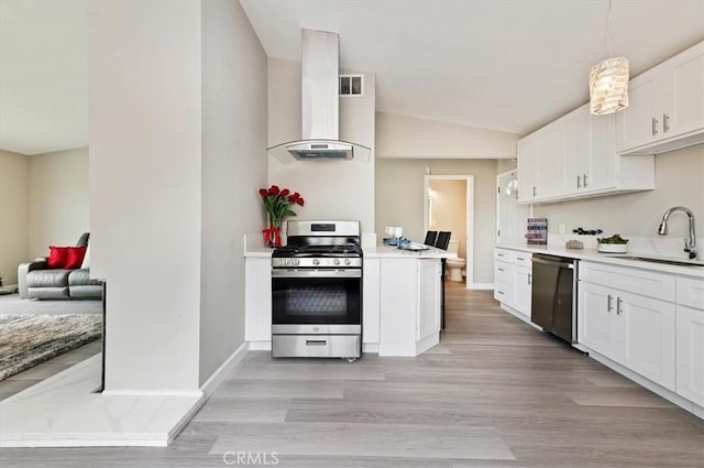 kitchen featuring a sink, wall chimney exhaust hood, stainless steel appliances, white cabinetry, and light wood-type flooring