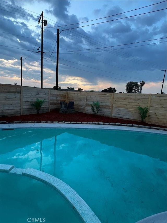 view of pool with a pool with connected hot tub and a fenced backyard