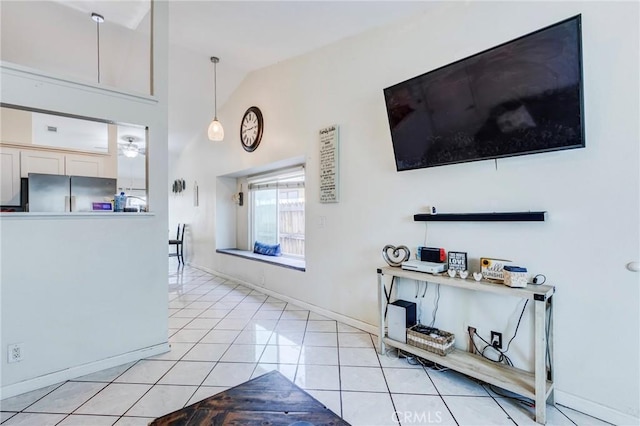 living area with baseboards, light tile patterned floors, and high vaulted ceiling