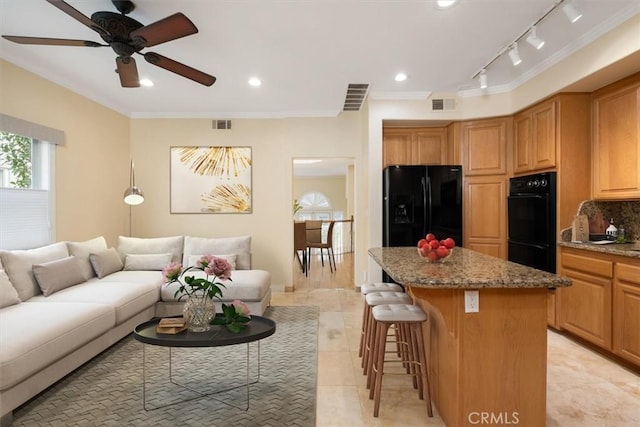 living room with crown molding, ceiling fan, rail lighting, and visible vents