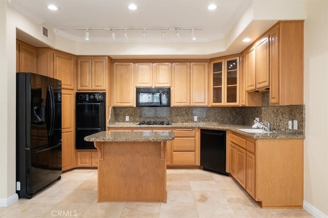 kitchen featuring visible vents, crown molding, a center island, light stone countertops, and black appliances
