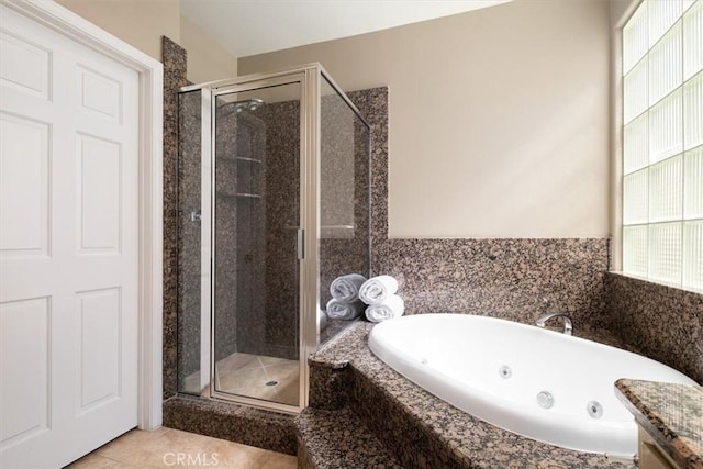 bathroom with a jetted tub, tile patterned flooring, and a stall shower