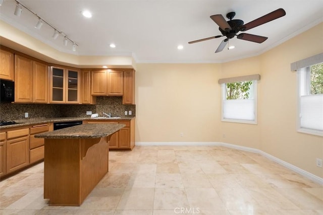 kitchen featuring a kitchen island, crown molding, tasteful backsplash, a sink, and black appliances