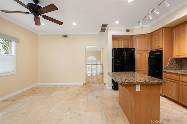 kitchen with visible vents, ornamental molding, black appliances, and a center island