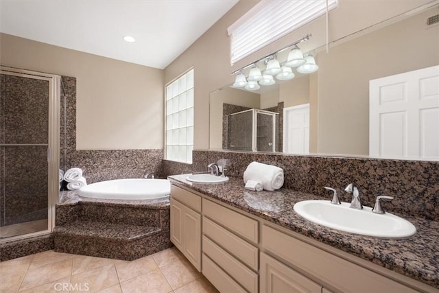 bathroom with double vanity, a garden tub, a stall shower, a sink, and tile patterned floors