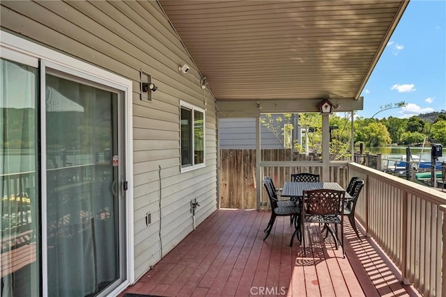 wooden deck with outdoor dining space and a water view