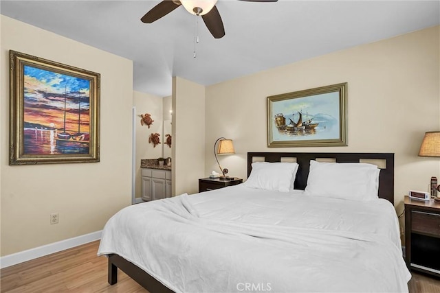 bedroom featuring ceiling fan, baseboards, ensuite bathroom, and wood finished floors