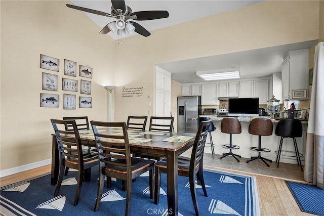 dining room with ceiling fan and light wood-style flooring