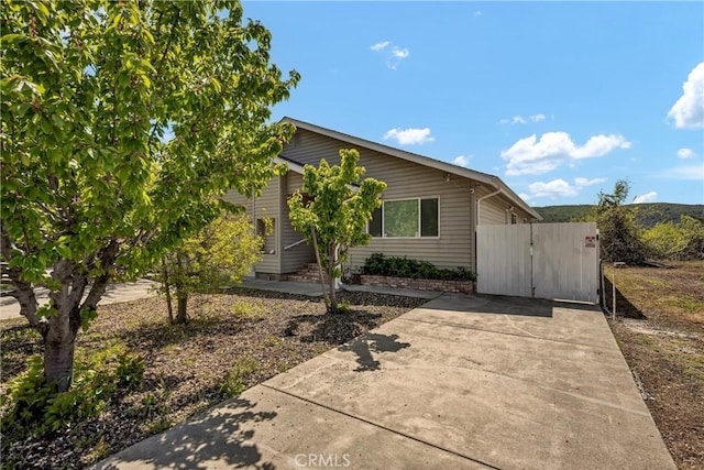 view of front of property featuring driveway and a gate