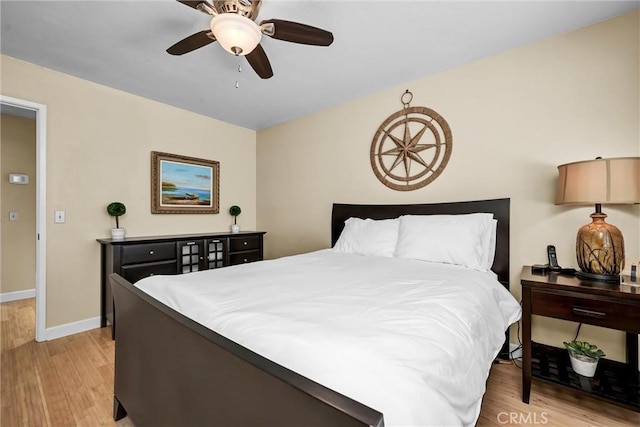 bedroom featuring baseboards, ceiling fan, and light wood finished floors