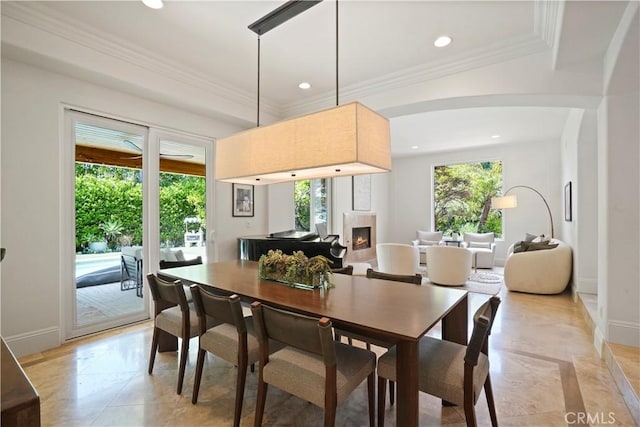 dining area featuring recessed lighting, baseboards, and a warm lit fireplace