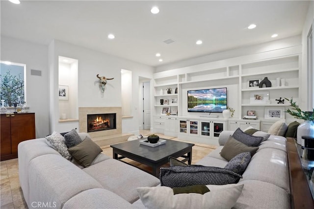 living area with recessed lighting, built in features, visible vents, and a fireplace