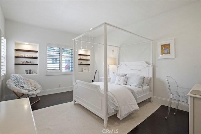 bedroom featuring baseboards and wood finished floors