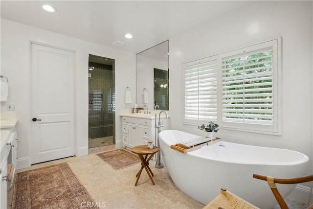 full bathroom featuring vanity, recessed lighting, a freestanding tub, and a shower stall
