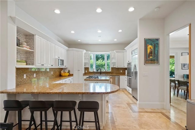 kitchen with open shelves, built in appliances, a peninsula, recessed lighting, and light stone counters