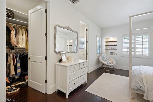 bedroom with visible vents, dark wood-style flooring, baseboards, and a closet