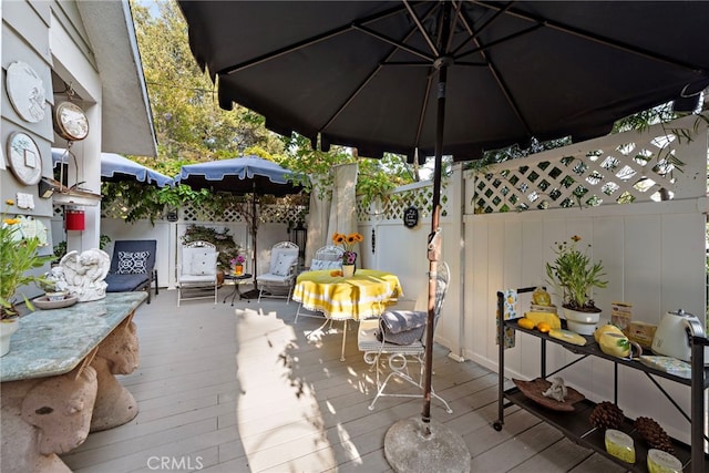 view of patio featuring a deck and fence