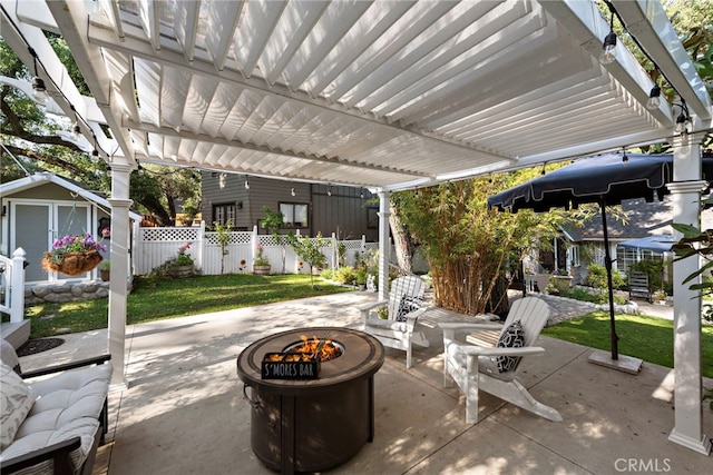 view of patio with a pergola, fence, a fire pit, and an outbuilding