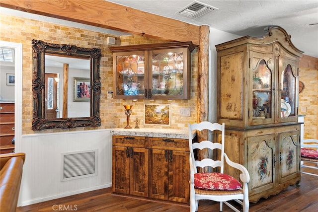 bar with dark wood-style flooring, visible vents, and a textured ceiling
