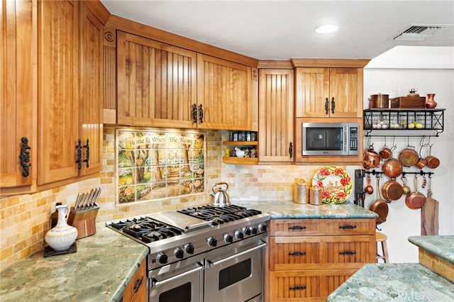 kitchen featuring light stone countertops, visible vents, backsplash, brown cabinets, and stainless steel appliances