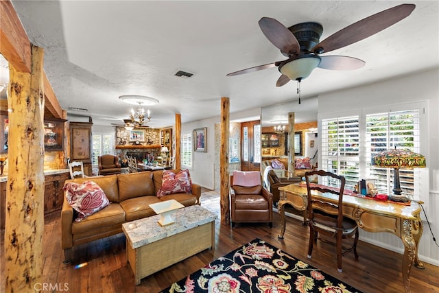 living room featuring dark wood finished floors, visible vents, and ceiling fan with notable chandelier