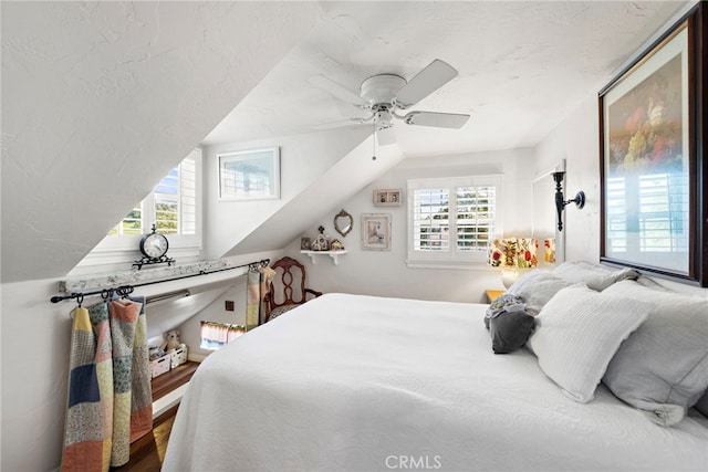 bedroom featuring multiple windows, a textured ceiling, and a ceiling fan