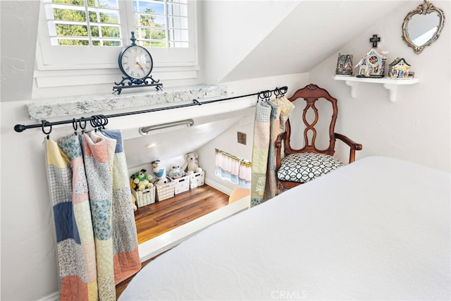 bedroom featuring lofted ceiling and wood finished floors