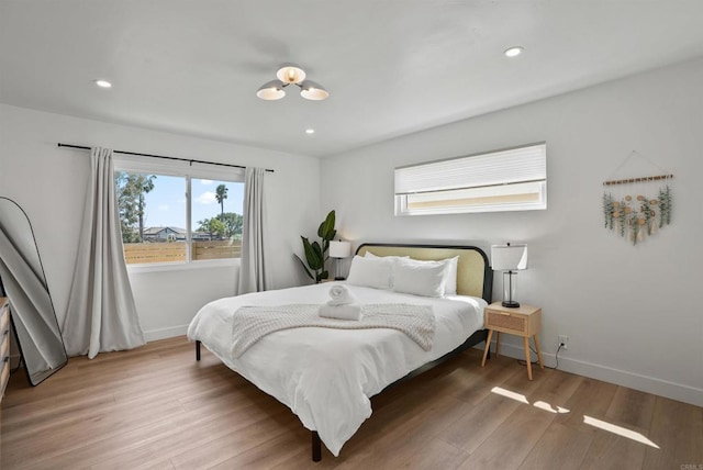 bedroom featuring baseboards, recessed lighting, and wood finished floors