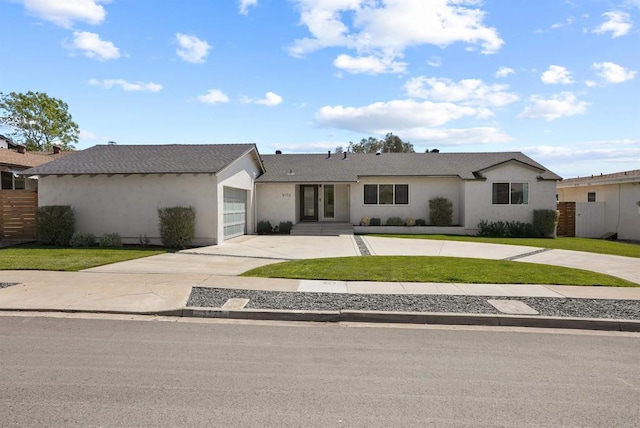 single story home with curved driveway, a garage, a front lawn, and stucco siding