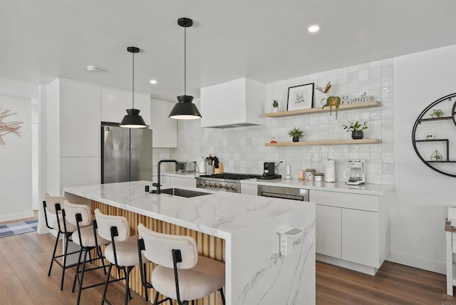 kitchen with freestanding refrigerator, modern cabinets, white cabinetry, tasteful backsplash, and a sink