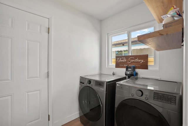 washroom featuring baseboards, laundry area, washing machine and dryer, and wood finished floors