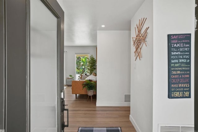 corridor featuring baseboards, recessed lighting, wood finished floors, and visible vents