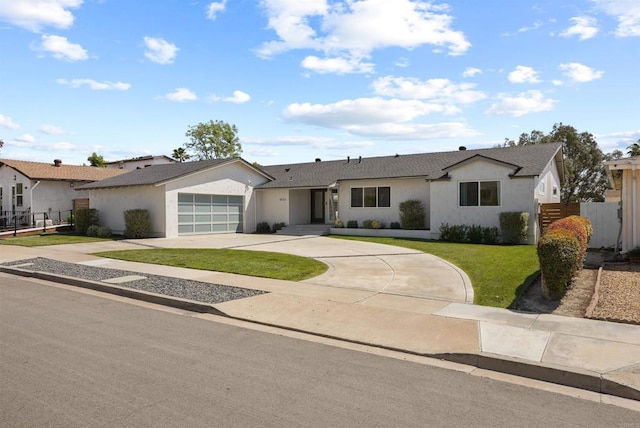ranch-style house featuring driveway, fence, a front lawn, an attached garage, and stucco siding
