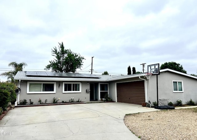 16041 Jersey St, Granada Hills, CA 91344 - ranch-style house with concrete driveway, an attached garage, solar panels, and stucco siding