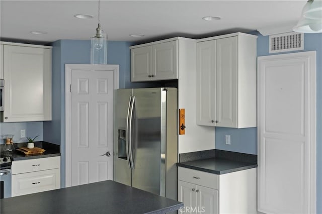 kitchen featuring dark countertops, stainless steel fridge with ice dispenser, white cabinetry, recessed lighting, and visible vents