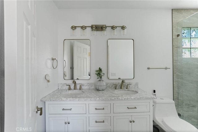 full bathroom featuring double vanity, toilet, tiled shower, and a sink