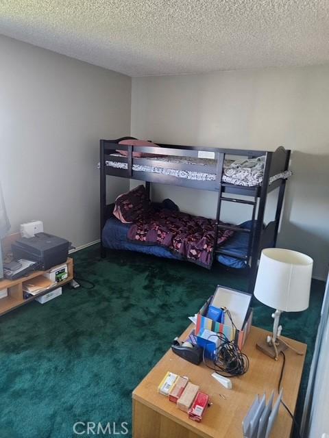 bedroom featuring carpet flooring and a textured ceiling