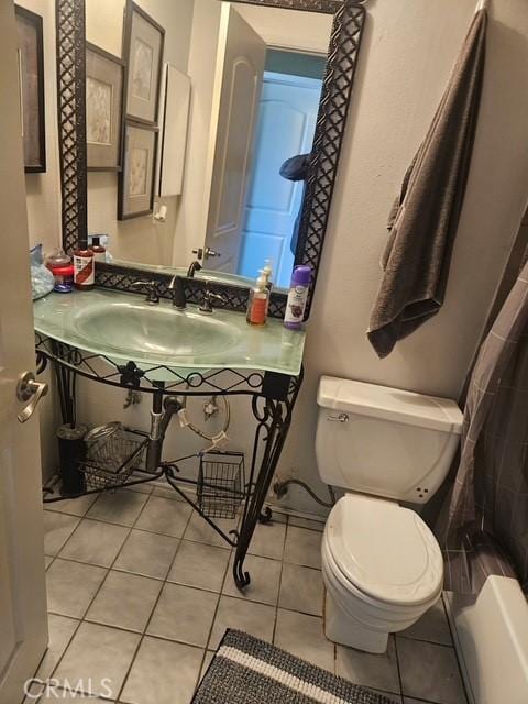 bathroom with a sink, tile patterned flooring, and toilet