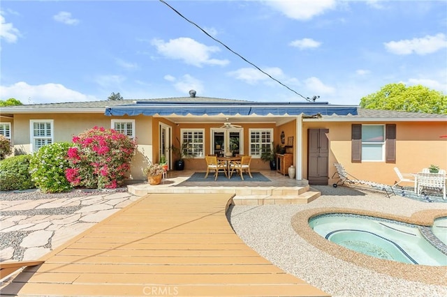 1215 Mira Monte Dr, Redlands, CA 92373 - rear view of house featuring an in-ground hot tub, stucco siding, a patio area, and outdoor dining space