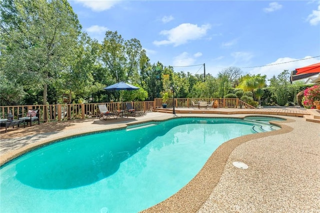 1215 Mira Monte Dr, Redlands, CA 92373 - view of swimming pool featuring a wooden deck, a pool with connected hot tub, view of scattered trees, and a patio