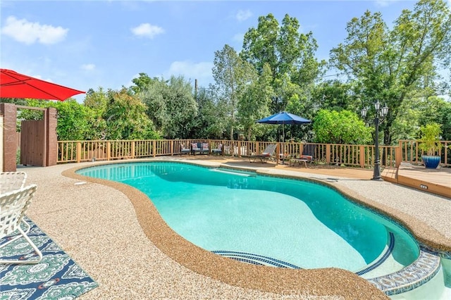 1215 Mira Monte Dr, Redlands, CA 92373 - view of swimming pool with a deck, view of wooded area, and fence