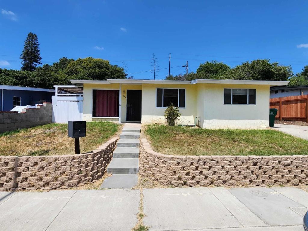 single story home with fence and stucco siding