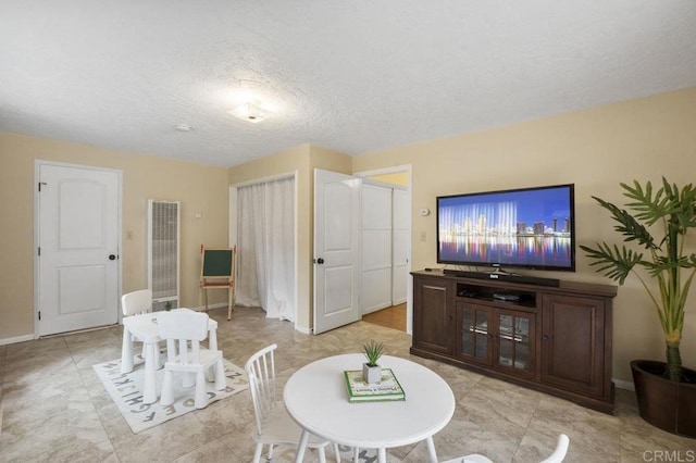 5566 Streamview Dr, San Diego, CA 92105 - living area featuring a heating unit, a textured ceiling, and baseboards
