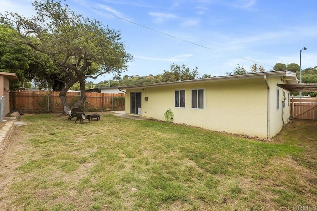 5566 Streamview Dr, San Diego, CA 92105 - rear view of property with a lawn, a fenced backyard, and stucco siding
